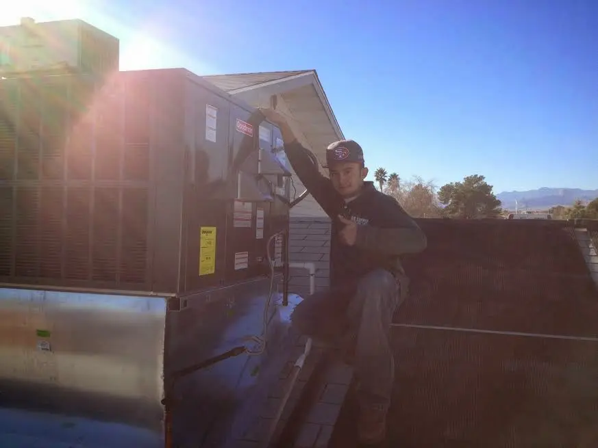 HVAC technician performing AC Tune-Up on a rooftop unit in Ravenna