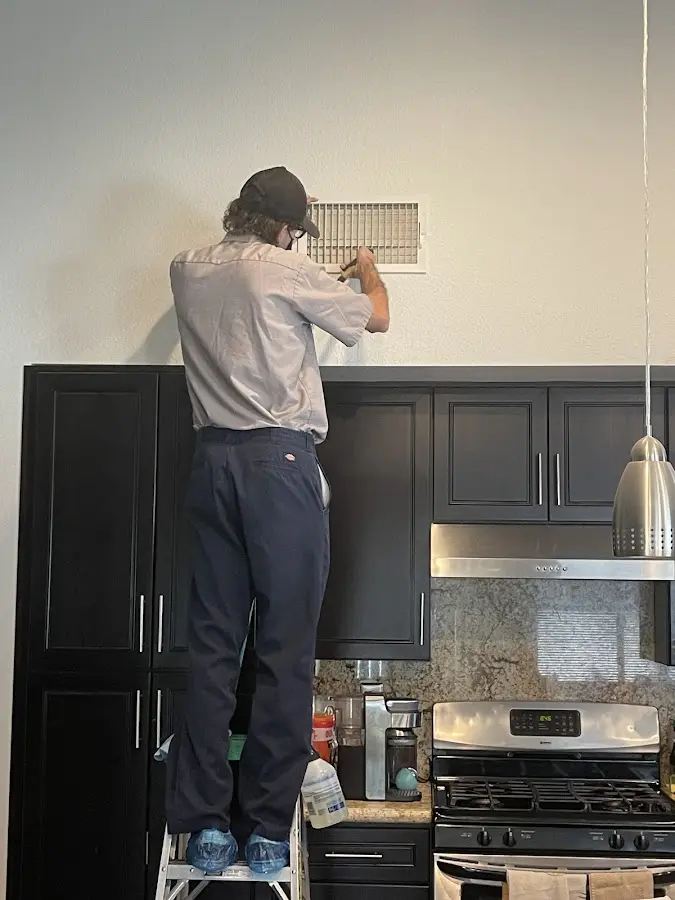 Technician inspecting an air vent during HVAC service in Ravenna